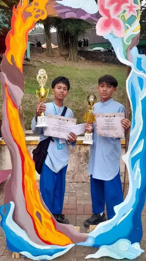 Dua murid memegang piala dan sertifikat juara SPACY 18