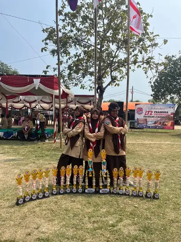 Regu Putri SMPIT Safinatunnajah berdiri di belakang deretan piala juara LT2