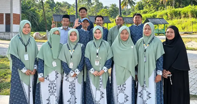 Para guru SMPIT Safinatunnajah berfoto bersama dengan seragam batik biru dan jilbab hijau